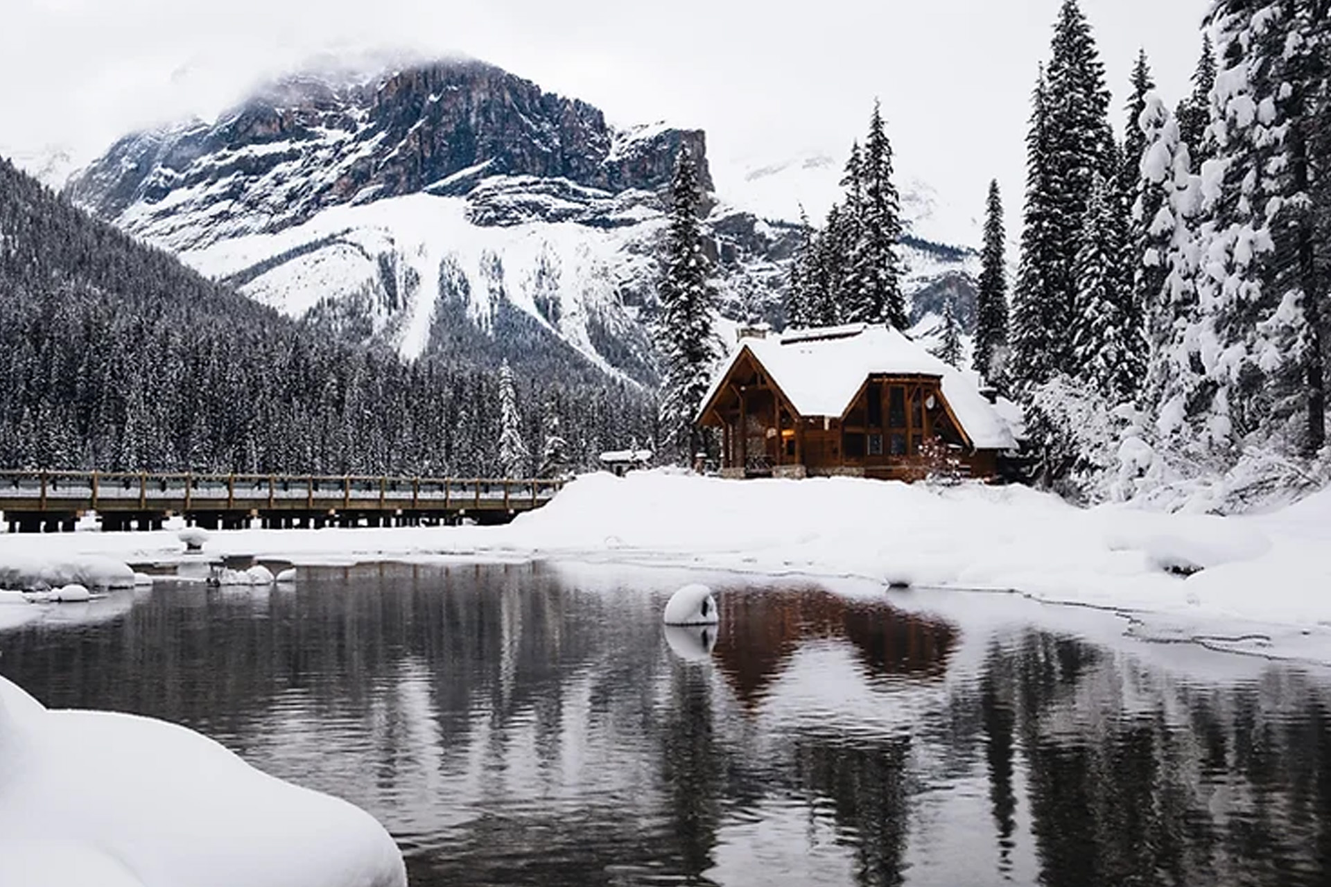 snowy cabin in the mountains scene depicting a classic northern winter