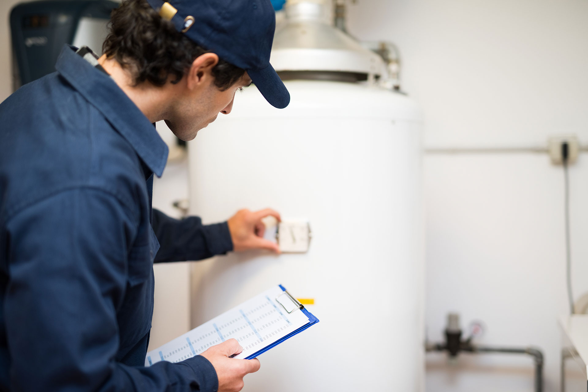 technician inspecting a newly installed traditional hot water tank